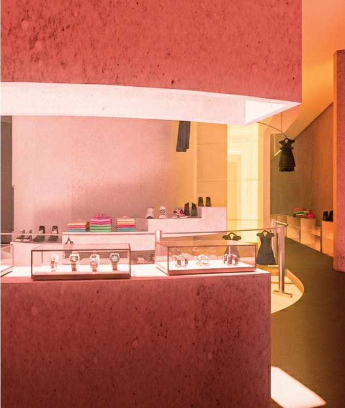 Rendering of the display floor washed in orange daylight, merchandise lit within a curved plaster wall.