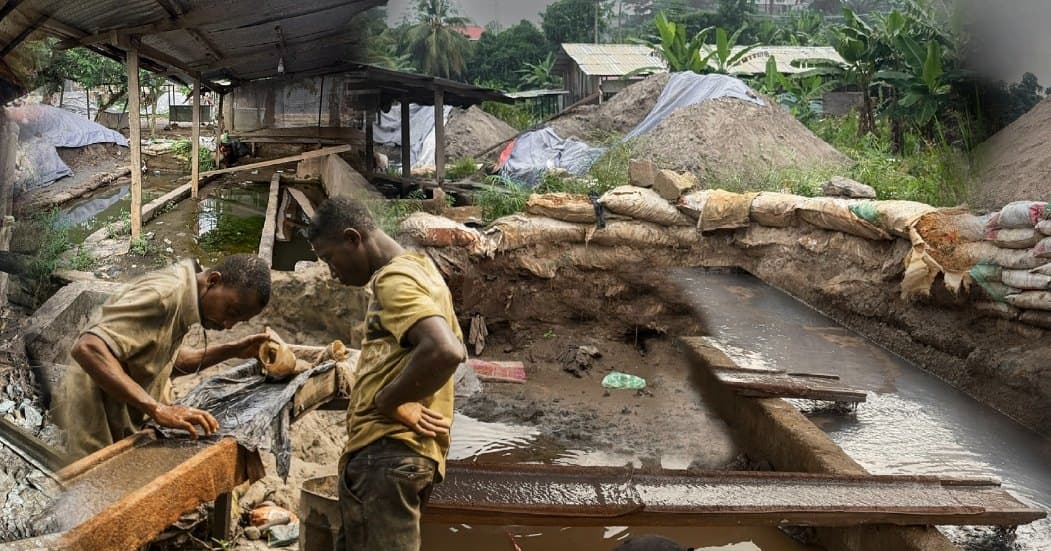 Two miners working at a sluice box beside sandbag-lined pits, with sheet-roofed shelters and mounded earth behind them.